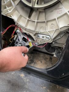 Removing motor fixing bolts on a Hoover washing machine